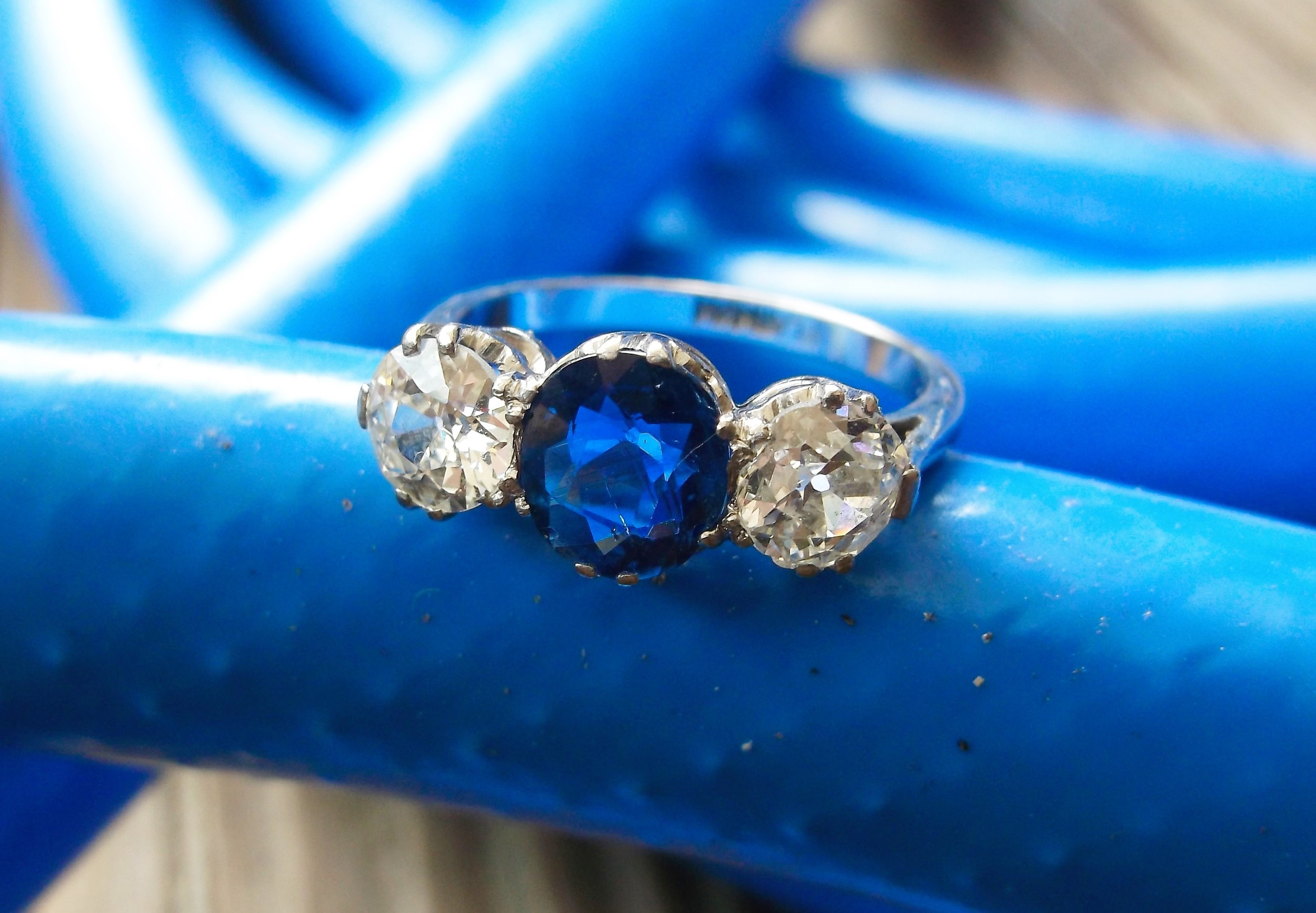 SOLD - Boldly beautiful 1920's diamond and sapphire ring with a 1.24 carat blue sapphire in the center and a 0.55 carat Old Mine cut diamond on each side.