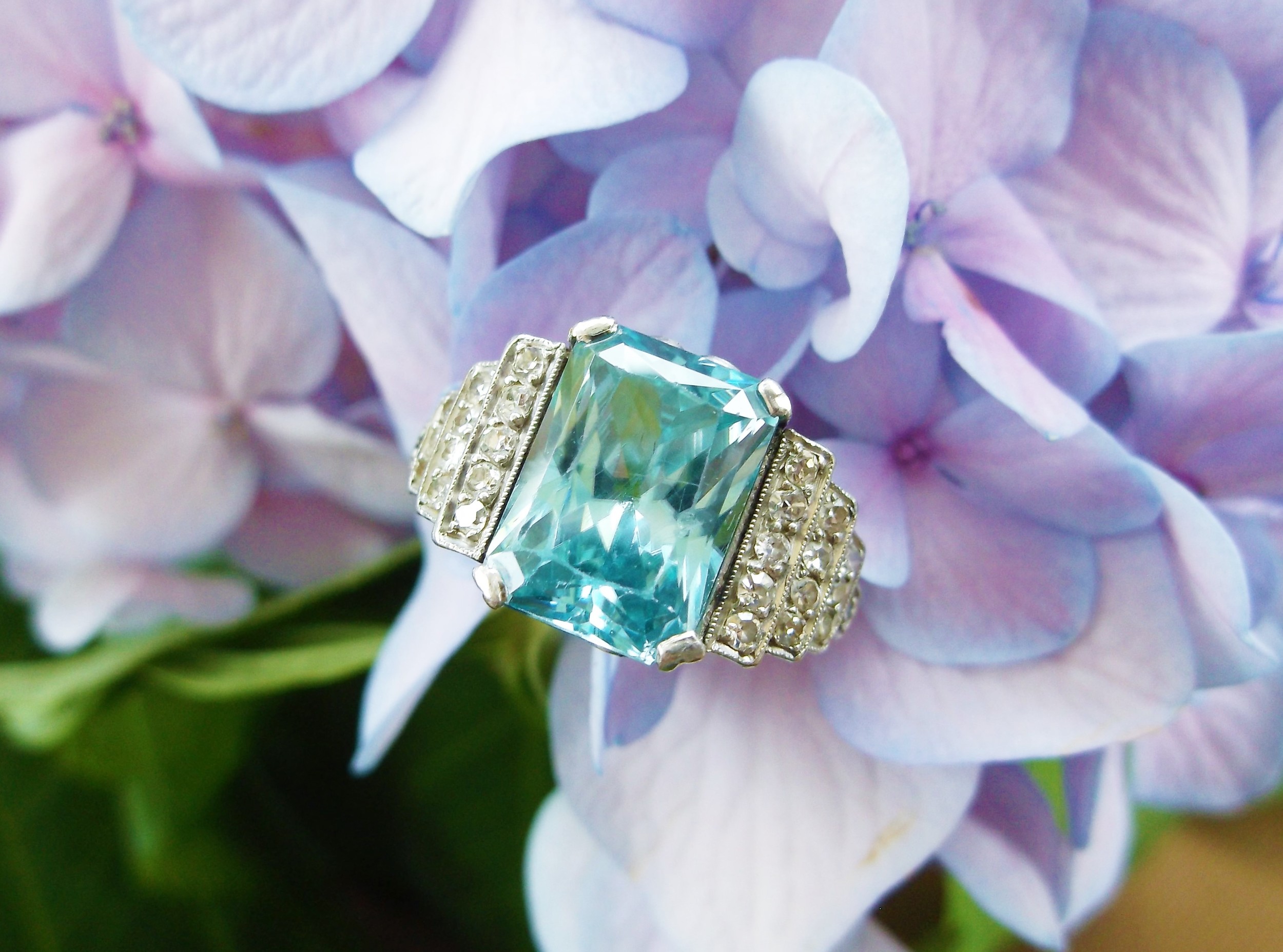SOLD - Dynamic 1920's 5.72 carat blue zircon set in platinum with 0.10 carats total weight in diamond details.