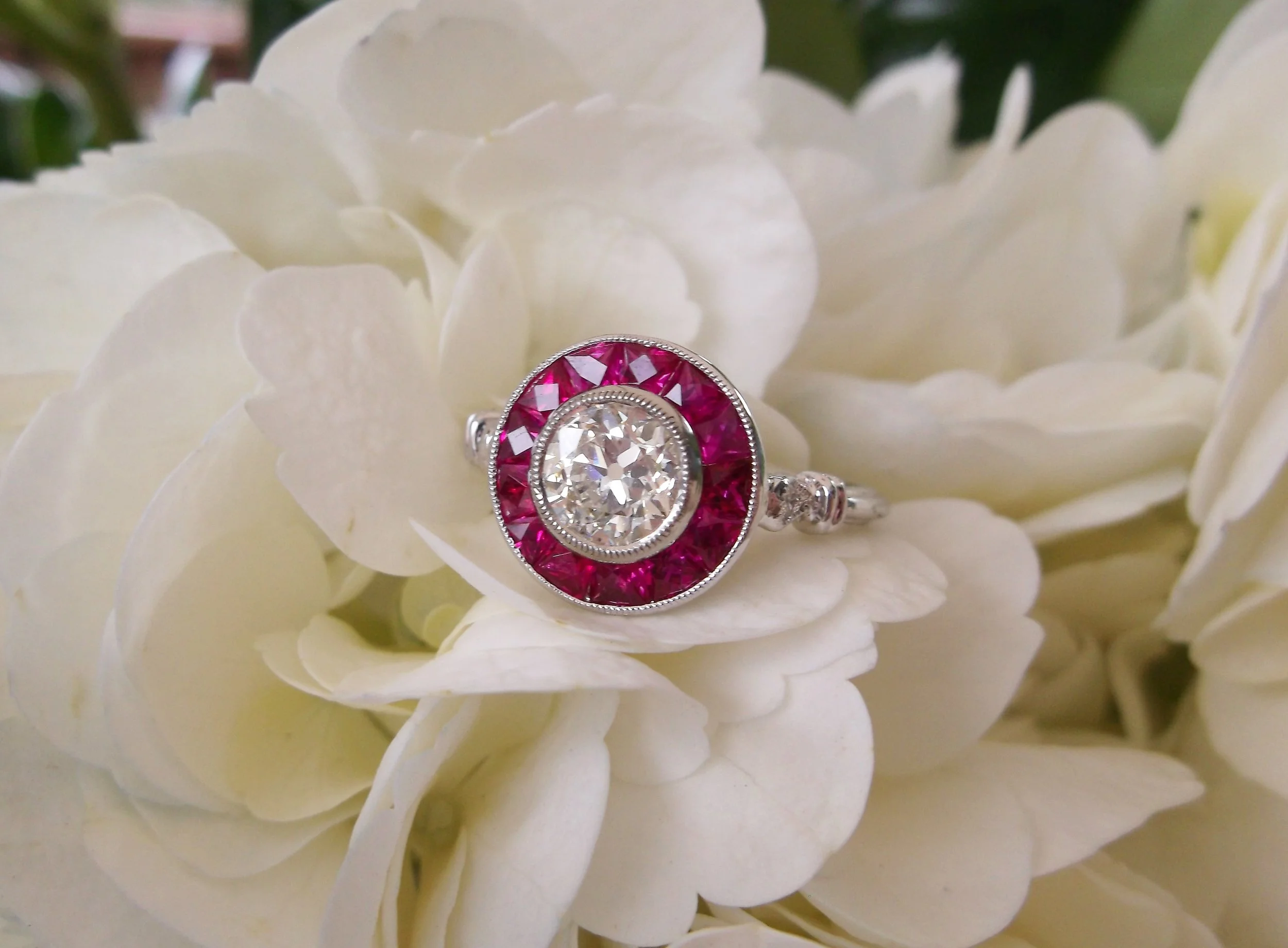 Dynamic 0.64 carat Old European cut diamond, encircled by decadent rubies.