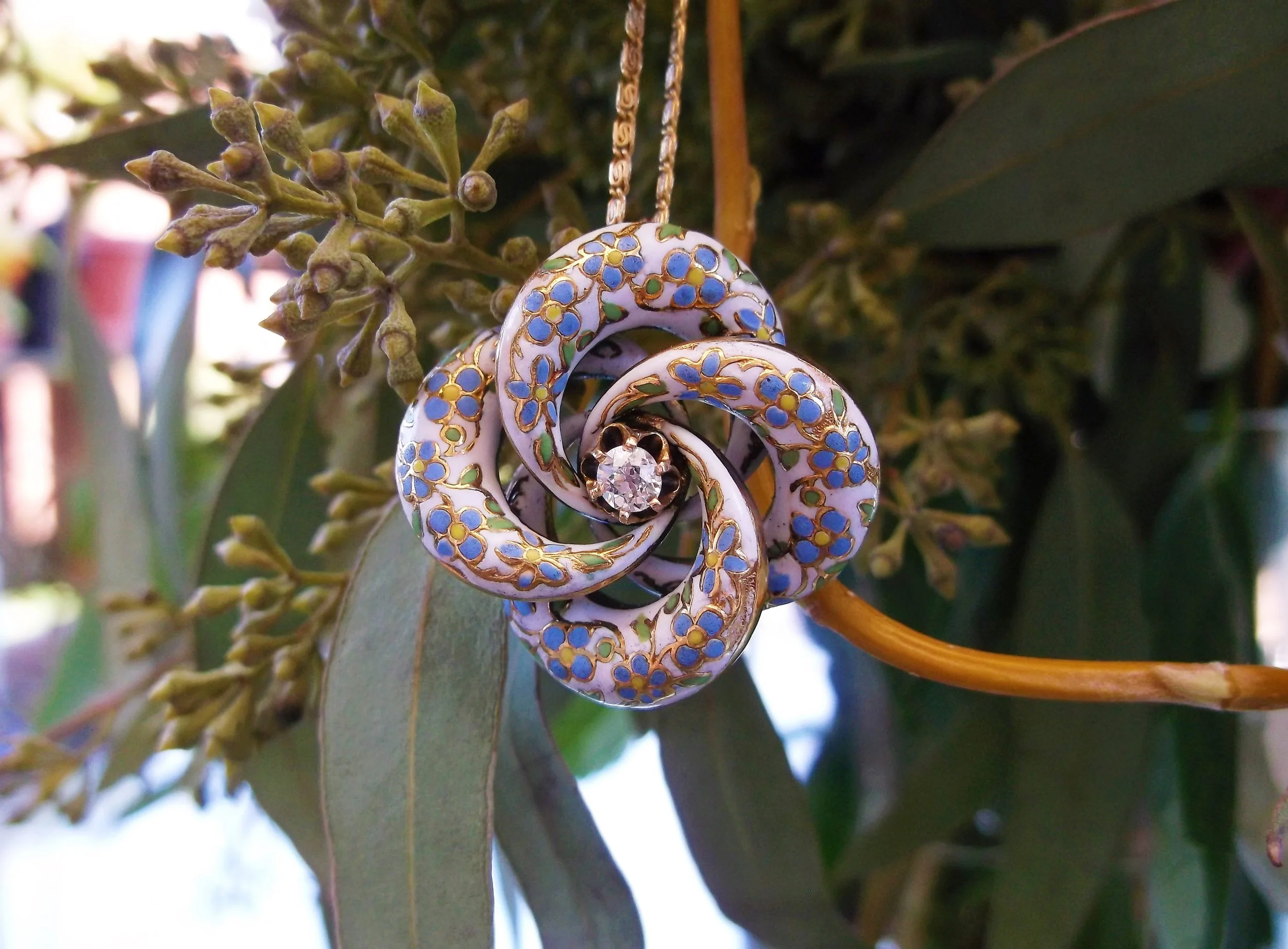 SOLD - Love springs eternal with this beautifully enameled Victorian love knot pendant. The knot is set with one 0.20 carat Old Mine cut diamond in the center. (The knot is about the size of a half dollar.)