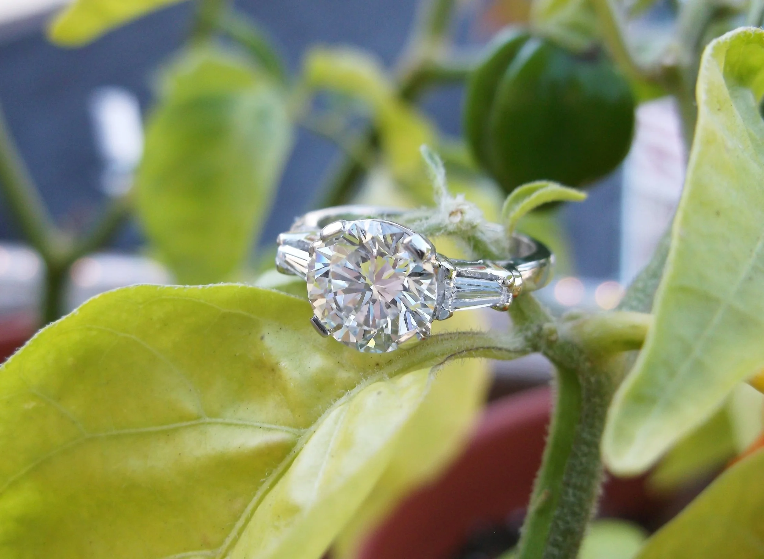 SOLD - Elegant and timeless 1.57 carat round brilliant cut diamond set in a platinum mounting with a baguette cut diamond on each side.