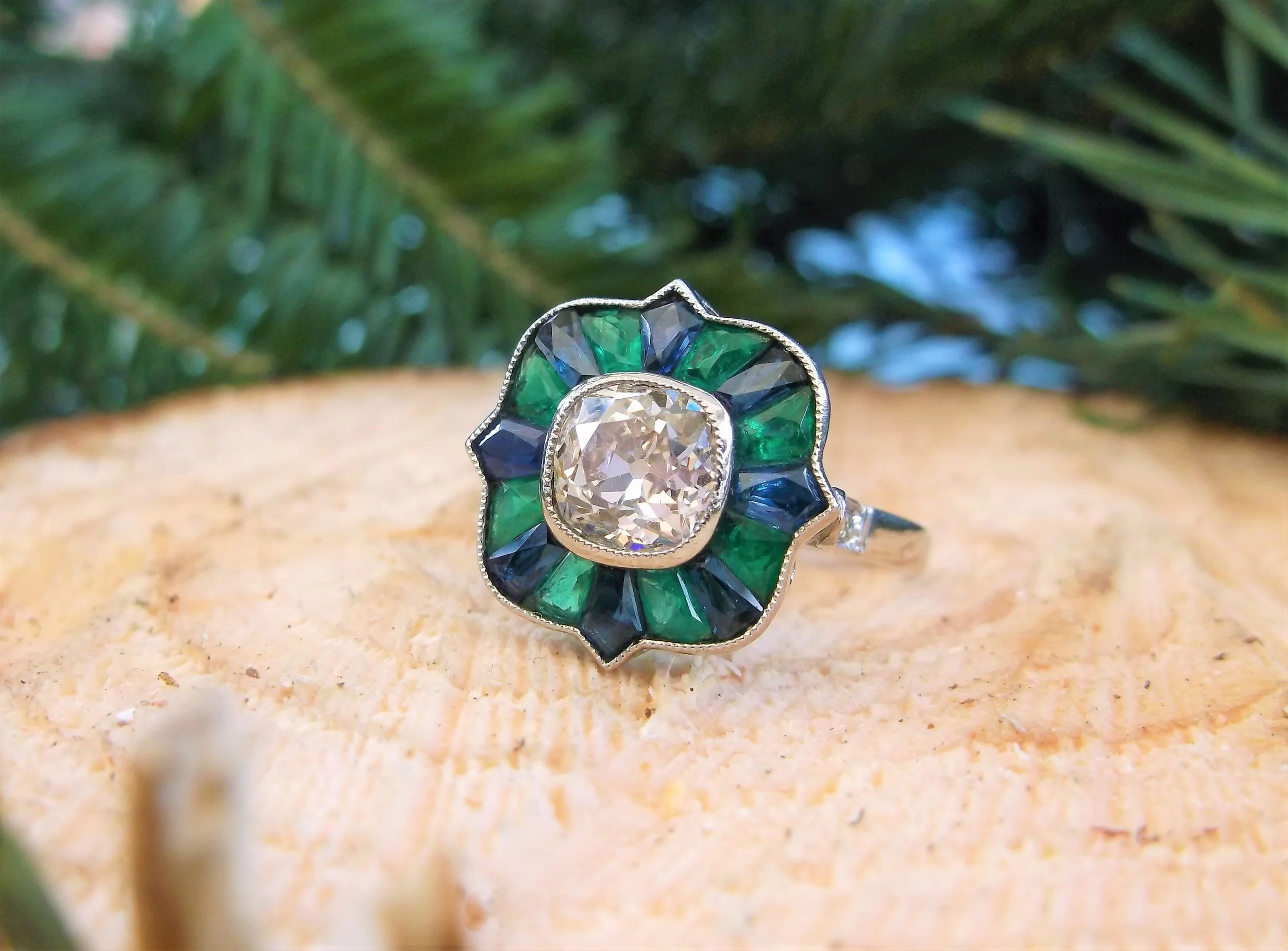 SOLD - An absolute show stopper! One of a kind 1920's ring set with a center 1.14 carat Old Mine cut diamond, surrounded by fancy cut emeralds and sapphires all set in platinum.