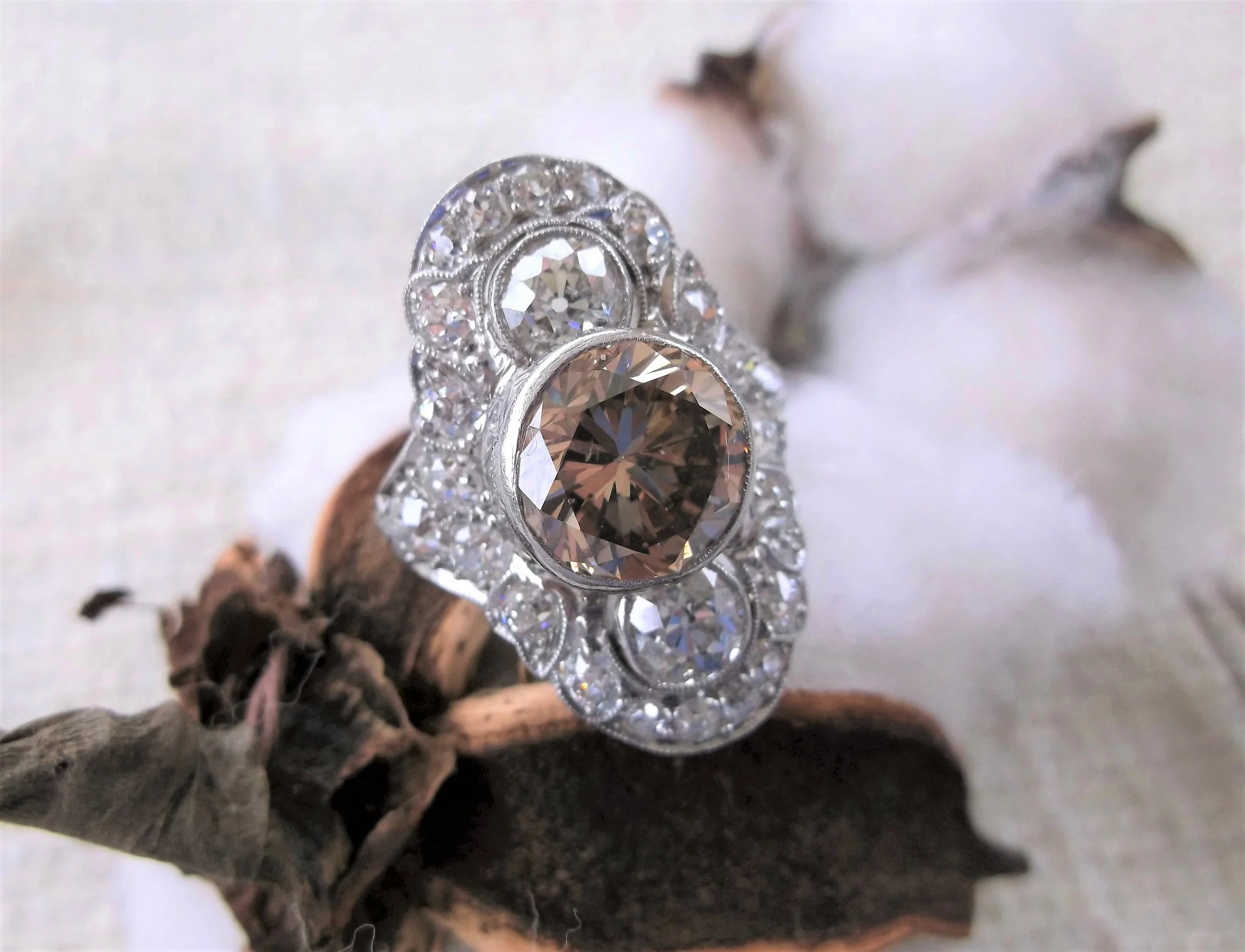 Captivating 3.73 carat fancy brown diamond, set in a beautiful platinum Art Deco mounting with an additional 3.50 carats total weight in Old Mine cut diamonds. 