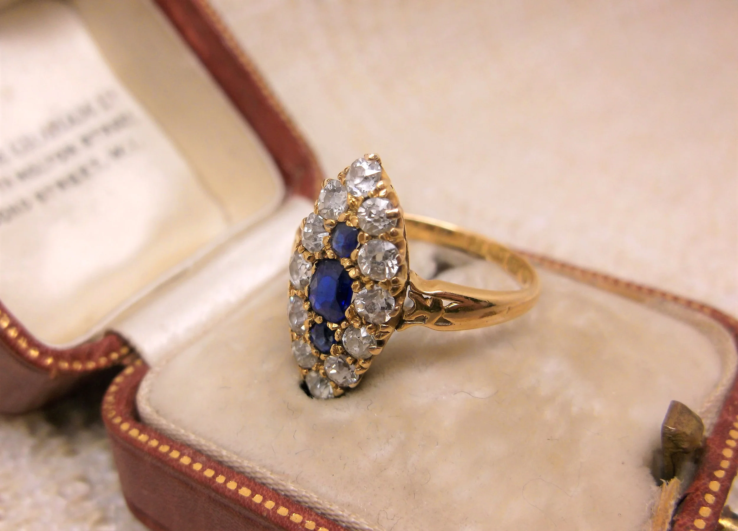 SOLD - "Amor Omnia Vincit" or "Love Conquers All" is beautifully inscribed in this 18K yellow gold, sapphire and Old Mine cut diamond navette ring from the year 1900.