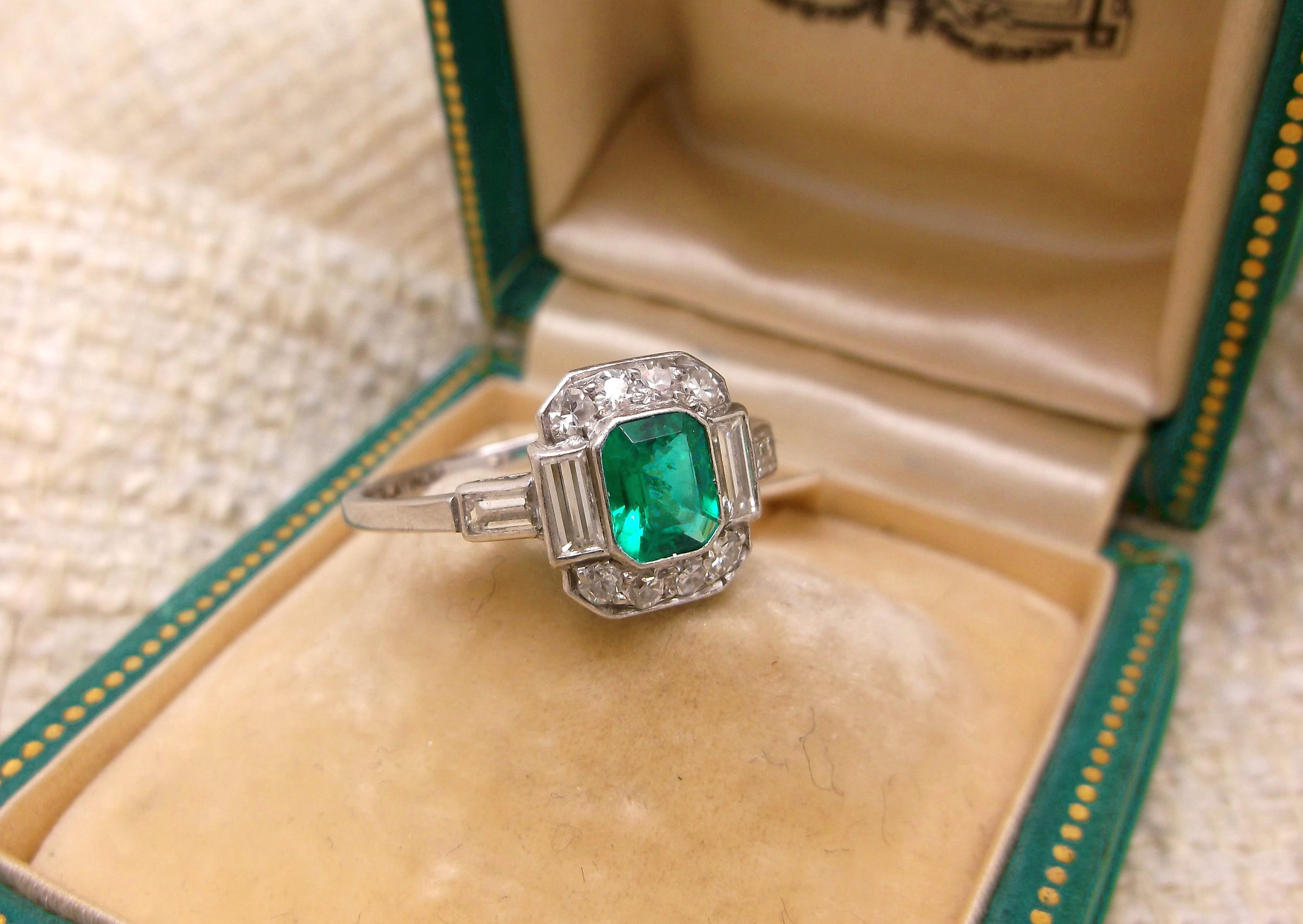 SOLD - Gorgeous Art Deco ring, featuring a center 0.50 carat emerald, surrounded by 0.70 carats total weight in diamonds, all set in platinum. 