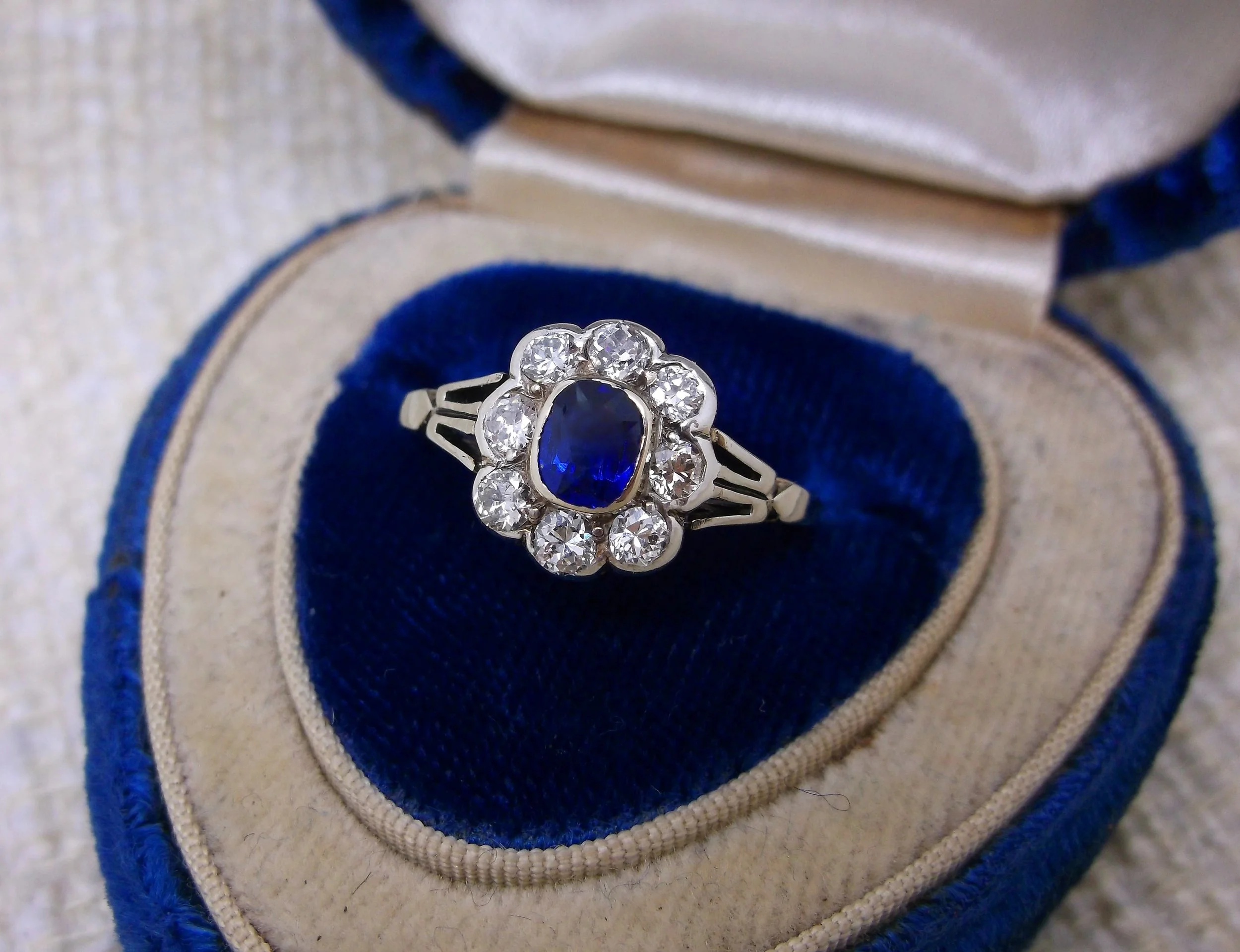 SOLD - Lovely Edwardian era diamond and sapphire ring. The ring is set with one center 0.36 carat blue sapphire, surrounded by a scalloped halo of 0.50 carats total weigh in Old European cut diamonds, all in platinum topped yellow gold. 