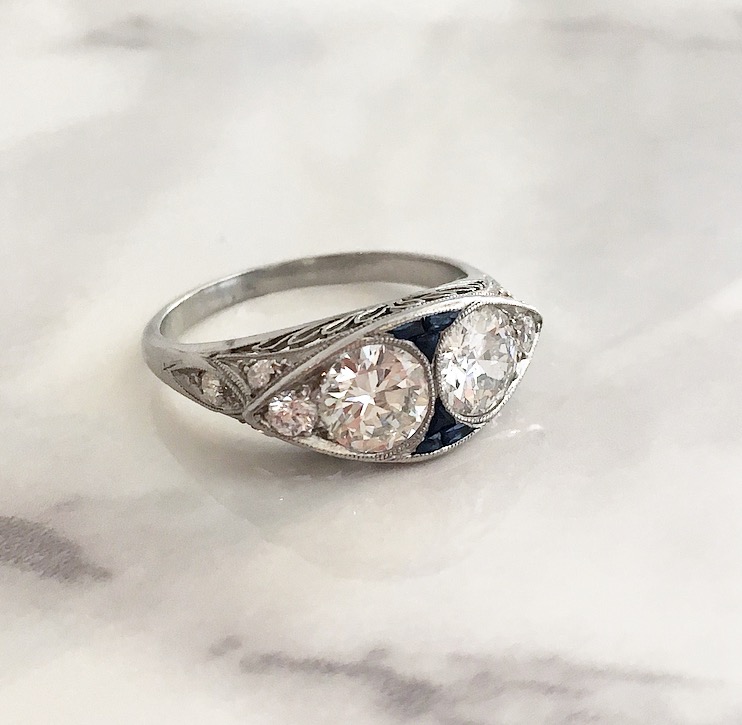 A pair of 0.55 carat each Old European cut diamonds set in a lovely platinum filigree mounting with 0.20 carats in accent diamonds and 0.15 carats in accent sapphires. 