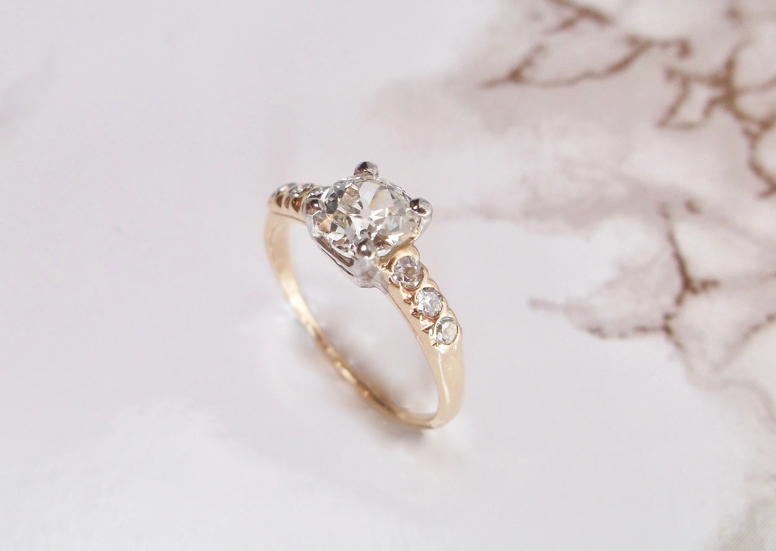 Timeless, two tone yellow gold and white gold Old Mine cut diamond ring. The ring is set with a gorgeous 0.81 carat Old Mine cut diamond, flanked on each side by three full cut round diamonds. Shop this classic look HERE