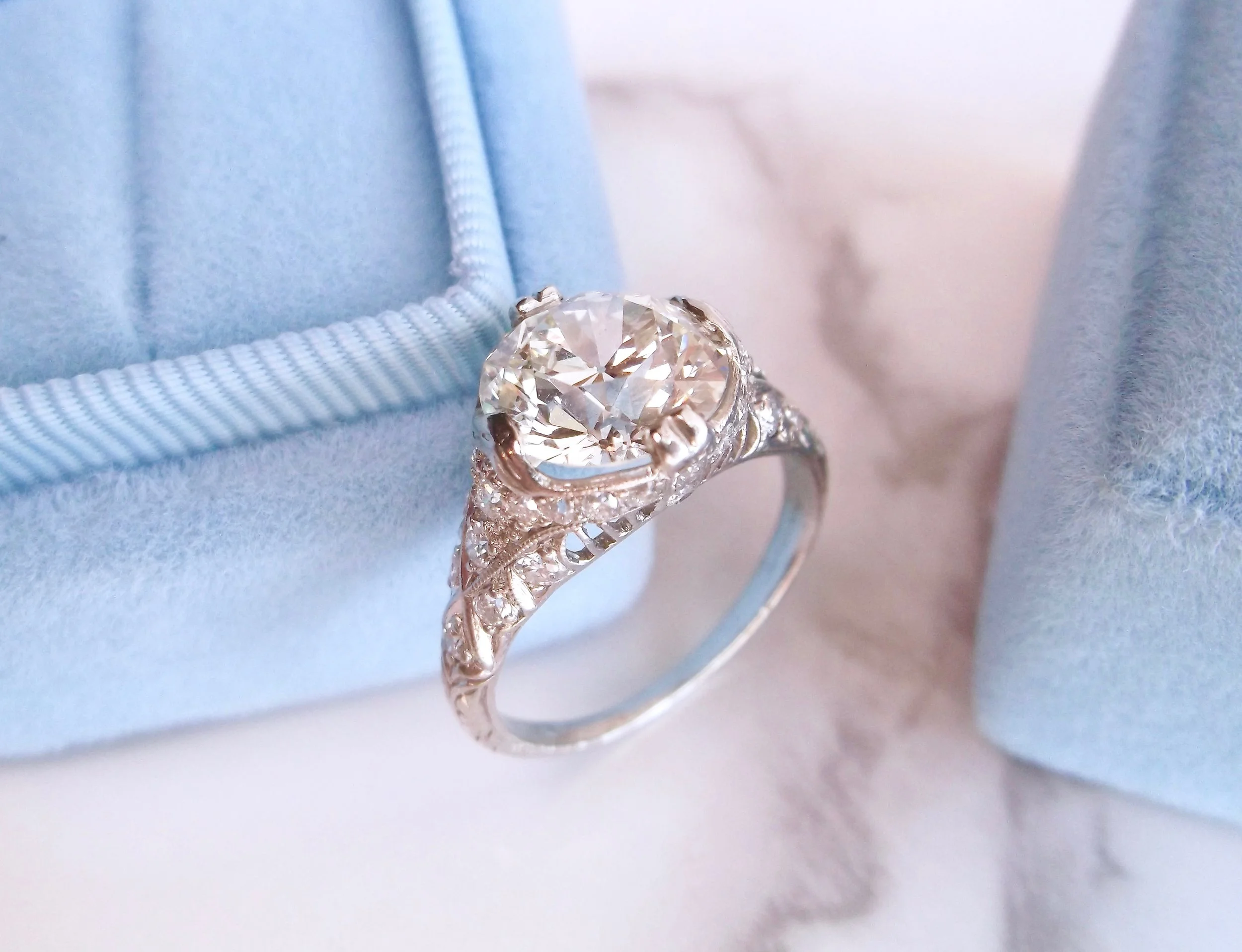 Exceptional 1920's diamond and platinum ring featuring a center 2.99 carat Old European cut diamond with gorgeous filigree and diamond accents in the mounting. Shop this ring HERE