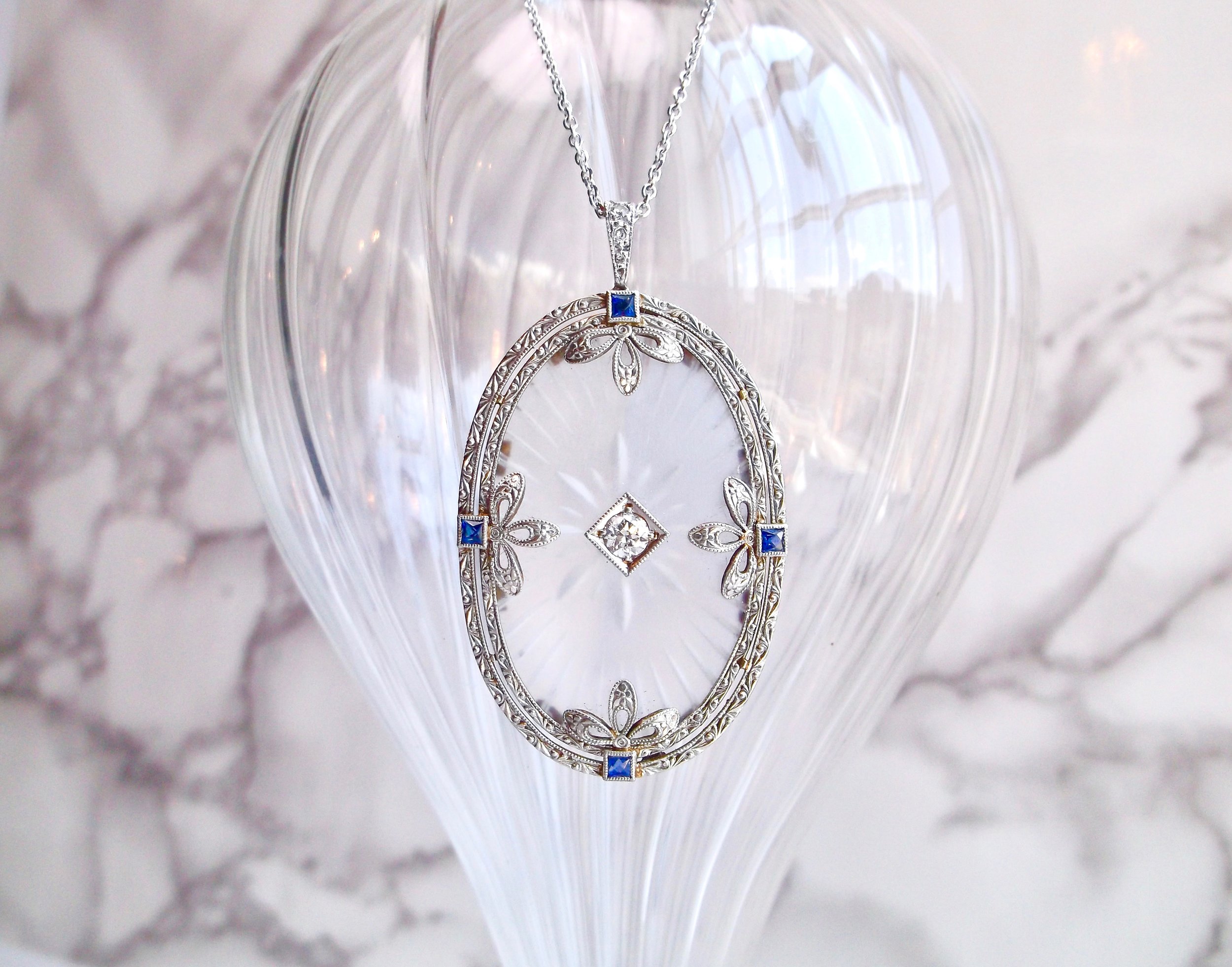 The feminine details in this Art Deco carved quartz, diamond and sapphire pendant are so dreamy! Featuring a center 0.20 carat Old Mine cut diamond set on a backdrop of beautifully carved quartz with sapphire accents, all set in platinum topped 18K yellow gold. Shop this beauty HERE