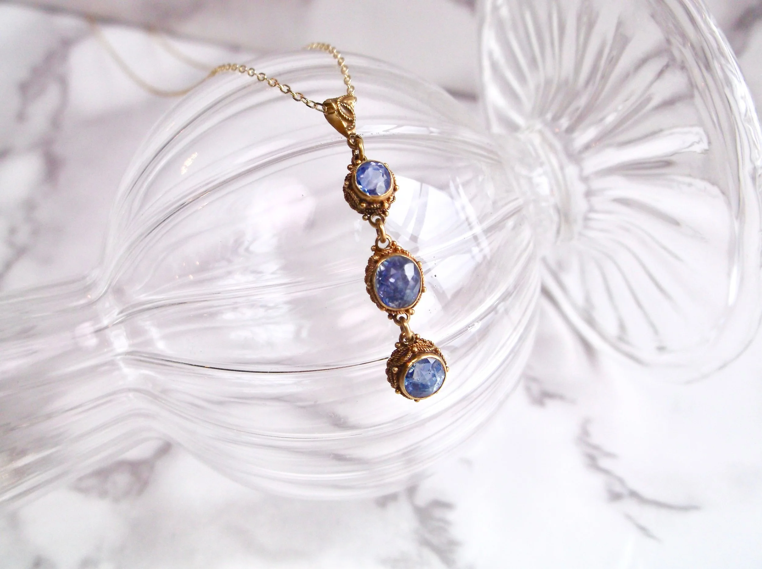 The prettiest pendant we ever did see! This lovely Victorian era drop pendant is set with three violet colored sapphires (1.00 carats total weight), each set in a detailed yellow gold bezel. Shop this pretty pendant HERE . 