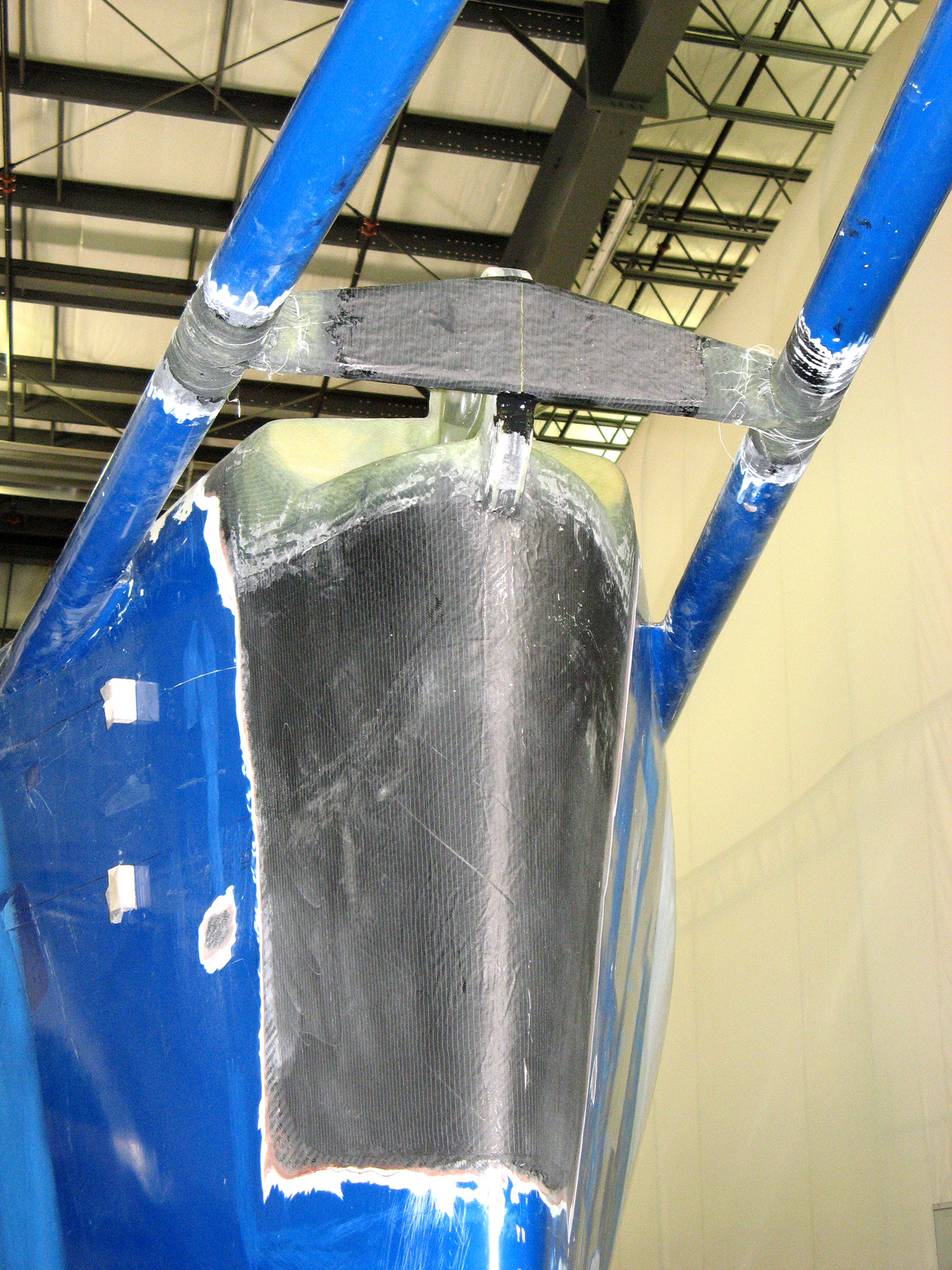  The repair required cutting away a section of 
            the bow to expose the solid carbon fiber centerline structure, repairing 
            and modifying the carbon fiber stem fitting, and then rebuilding, 
            fairing, and painting the