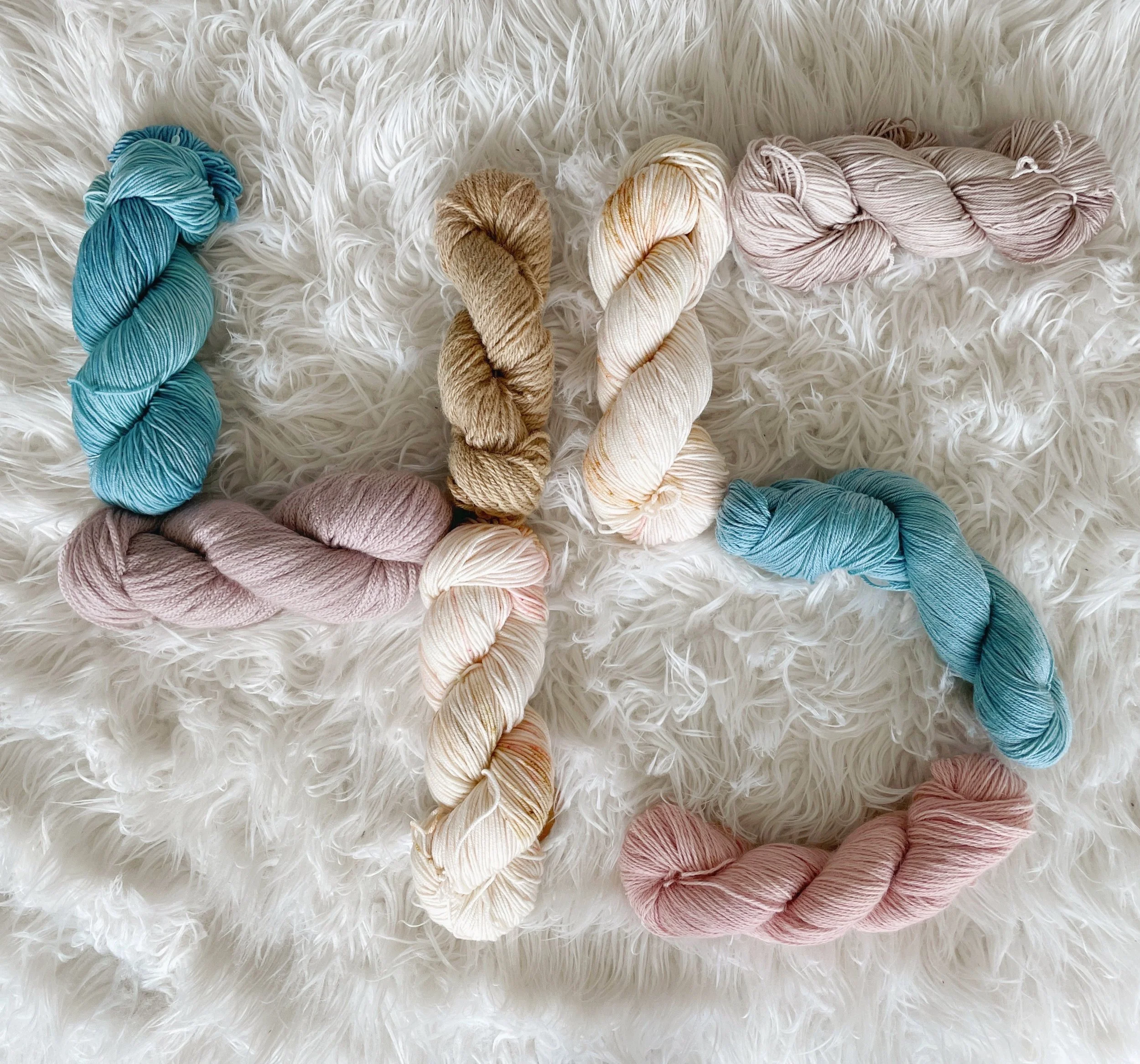 The number 45 spelled out with yarn skeins on a white faux fur rug.