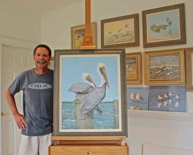 William R. Beebe with Feathered Friends painting and others in studio