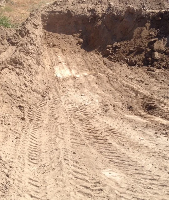 White cement from a wall appearing in the dirt