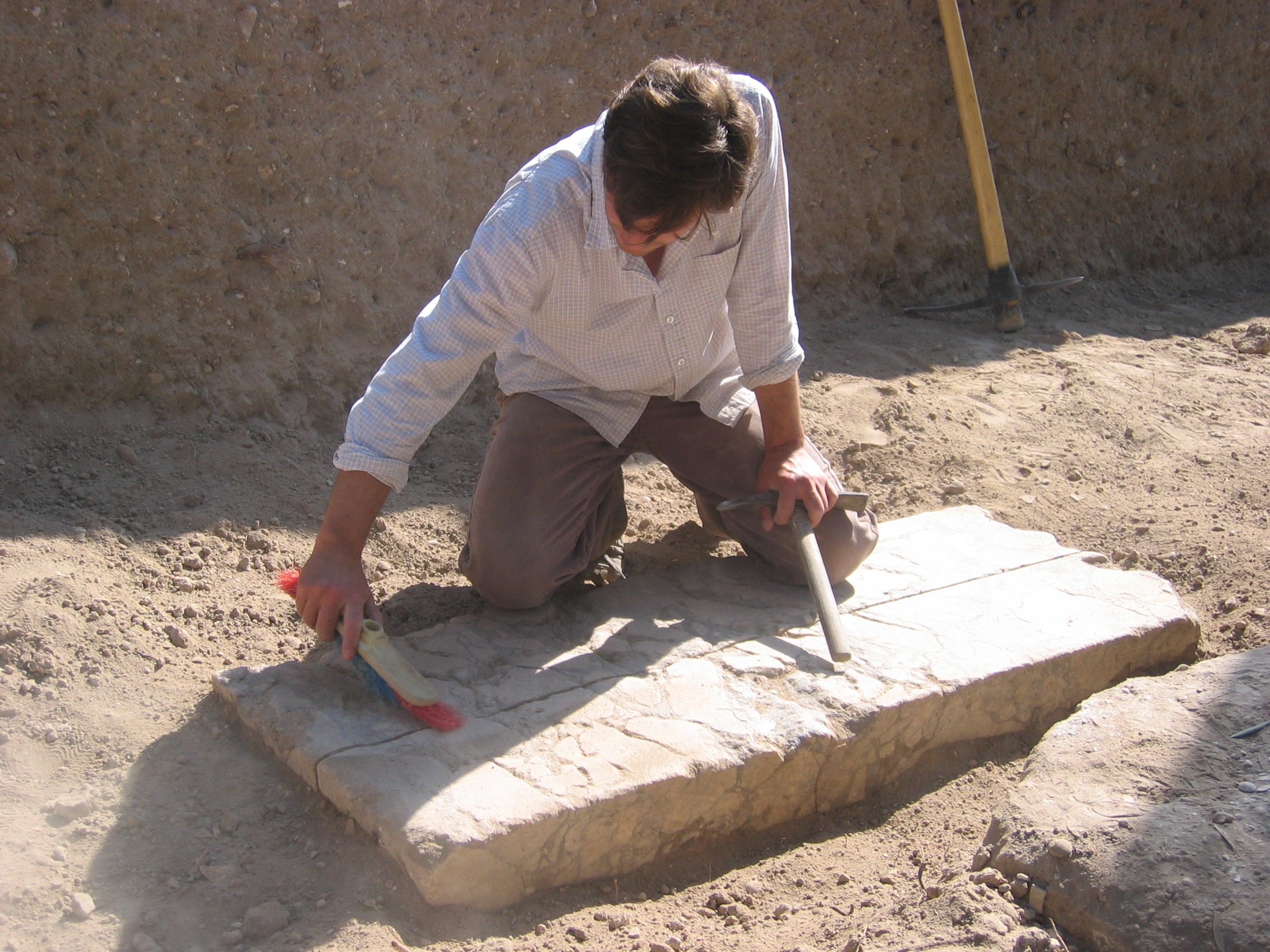 Ryan cleans off the remains of a column shaft found in Grid 47 -- 2010 field season