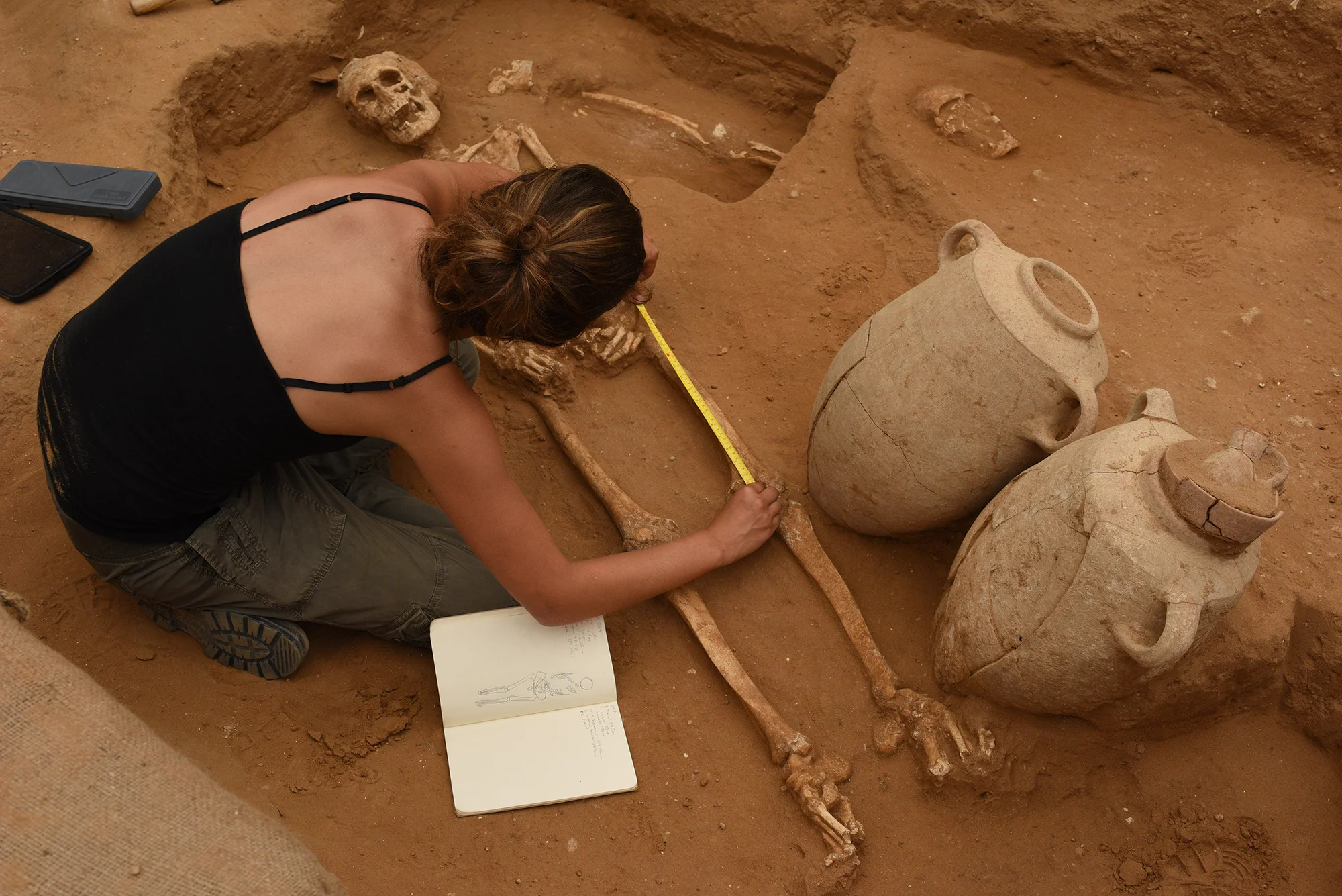 A member of the physical anthropology team, Rachel Kalisher, measures a 10th-9th century BC skeleton