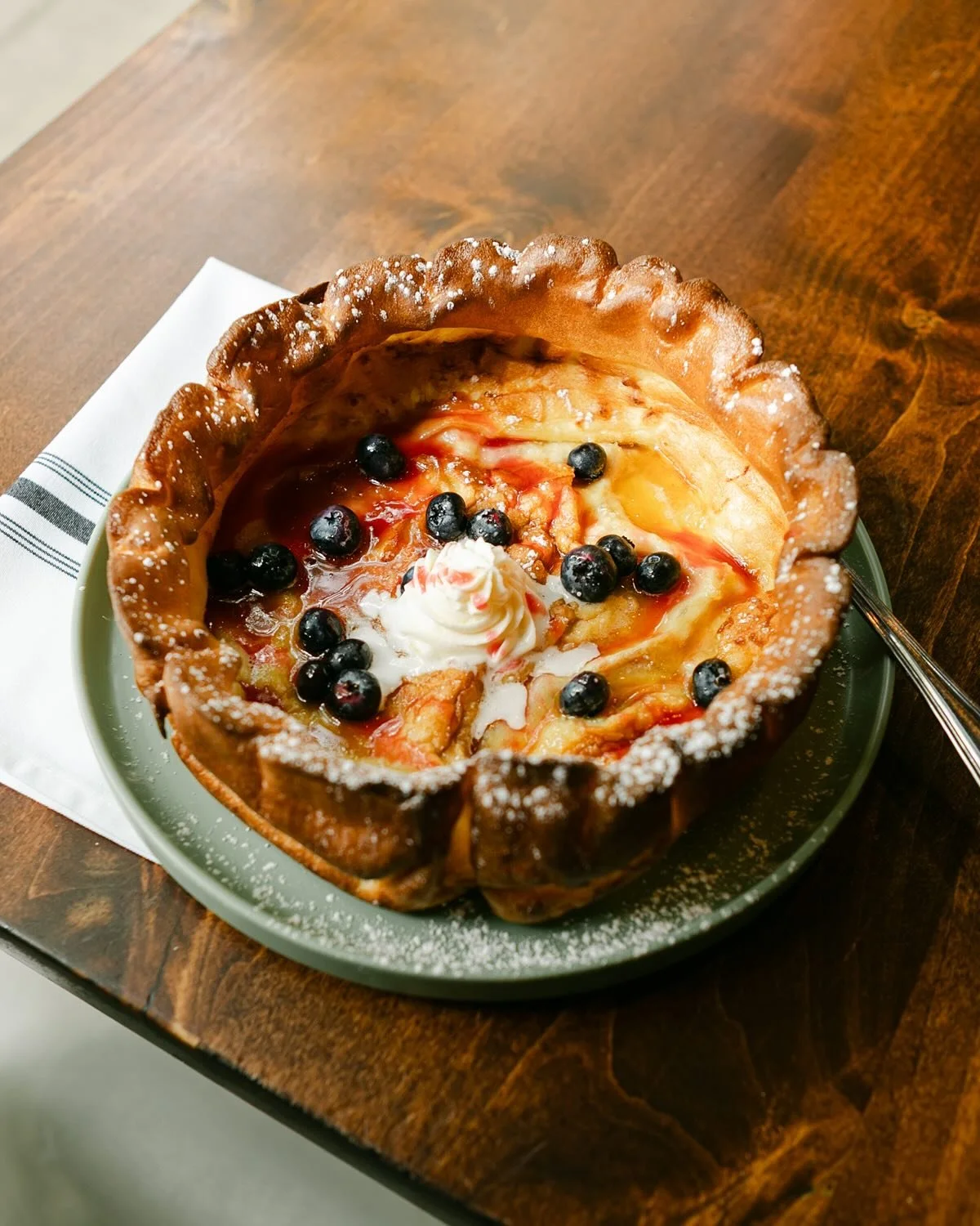 Weekend indulgence…yum! 
Our DUTCH BABY is made to order, baked until perfectly puffed, and served hot from the oven with lemon mascarpone, raspberry coulis, blueberries, Grade A amber maple syrup, and a dusting of powdered sugar.
Available d