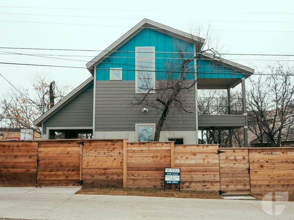 The house is in fact not a huge tower falling on top of you, but a nice two story with a wood fence.