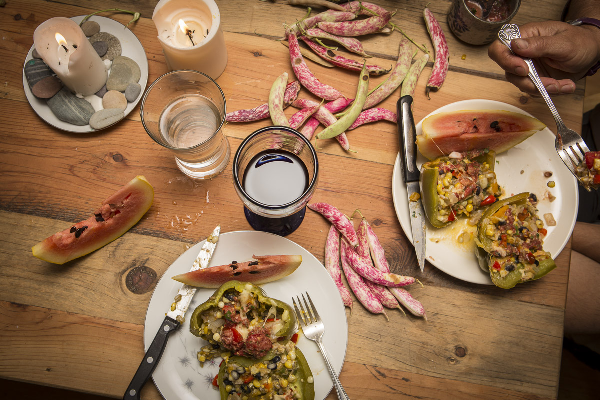 A meal of stuffed peppers, garden melon, and our own blackberry wine, on the barnboard table. Photo: Noah Jackson 