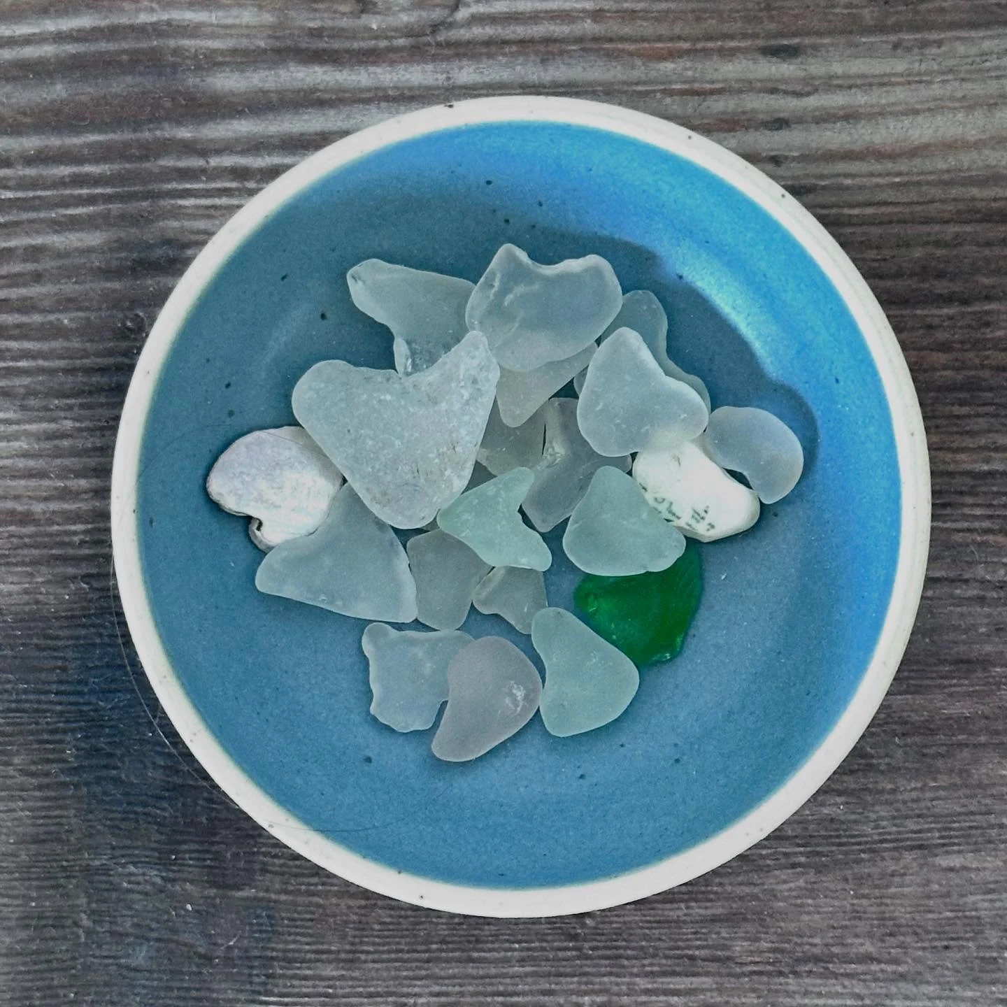 mermaid tears

across the Atlantic,
 along another shore
the  ocean opened.

a morning offering 
of broken hearts &ndash; 

 frosted lavender 
 
  milky white &amp;

  bold 
  bottled 
  blue 

glass shards &ndash;

their wounds
licked smooth 

by th