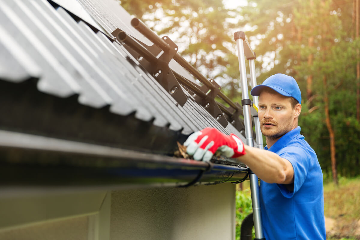 service man cleaning gutters on a hillsboro home