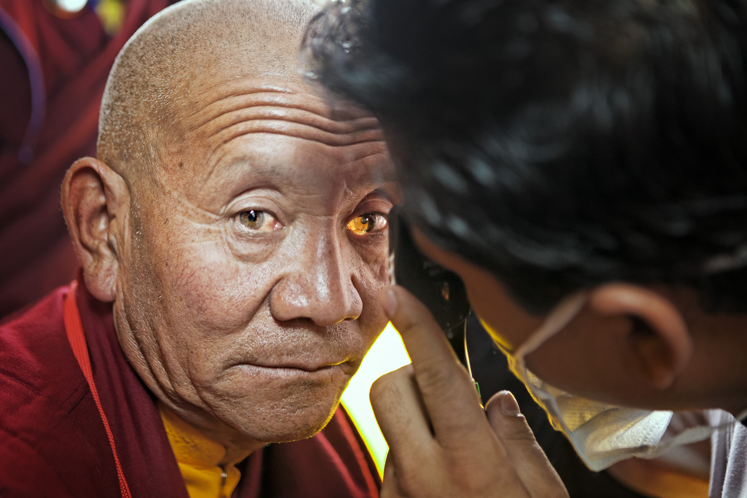 Monk having eyes checked, Hemis Monastery