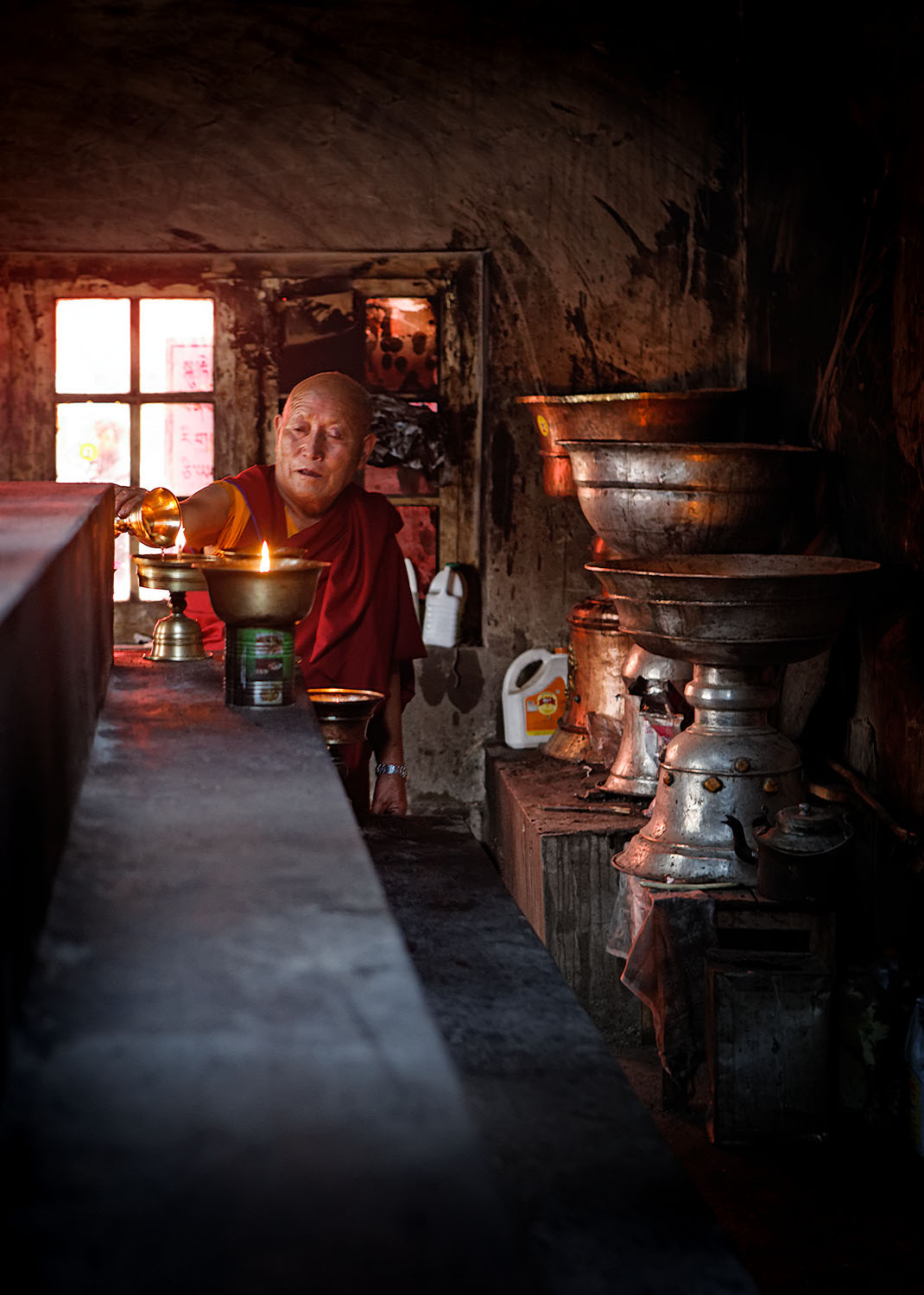 Lighting butter lamps, Hemis Monastery, Ladakh, India