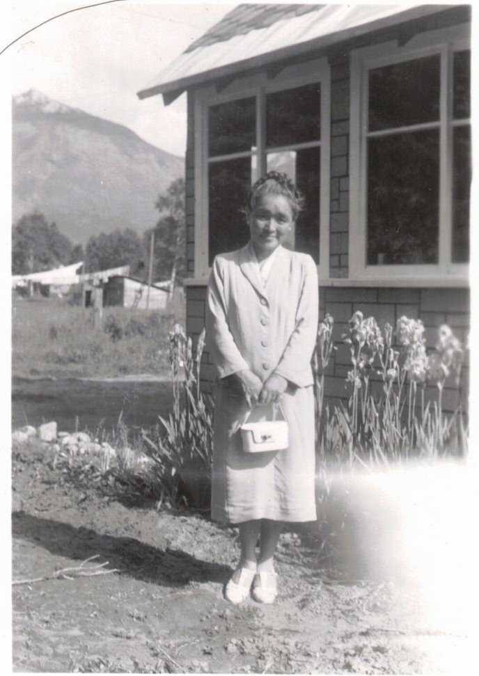 Mary Higano stands next to her house in Big Eddy. P-14444.