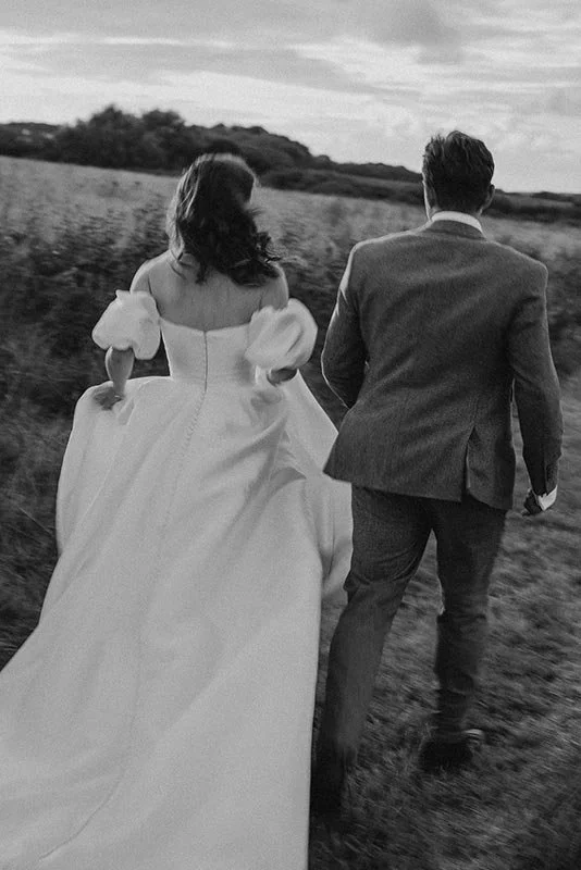 Editorial wedding photography, couple running in black and white with motion blur
