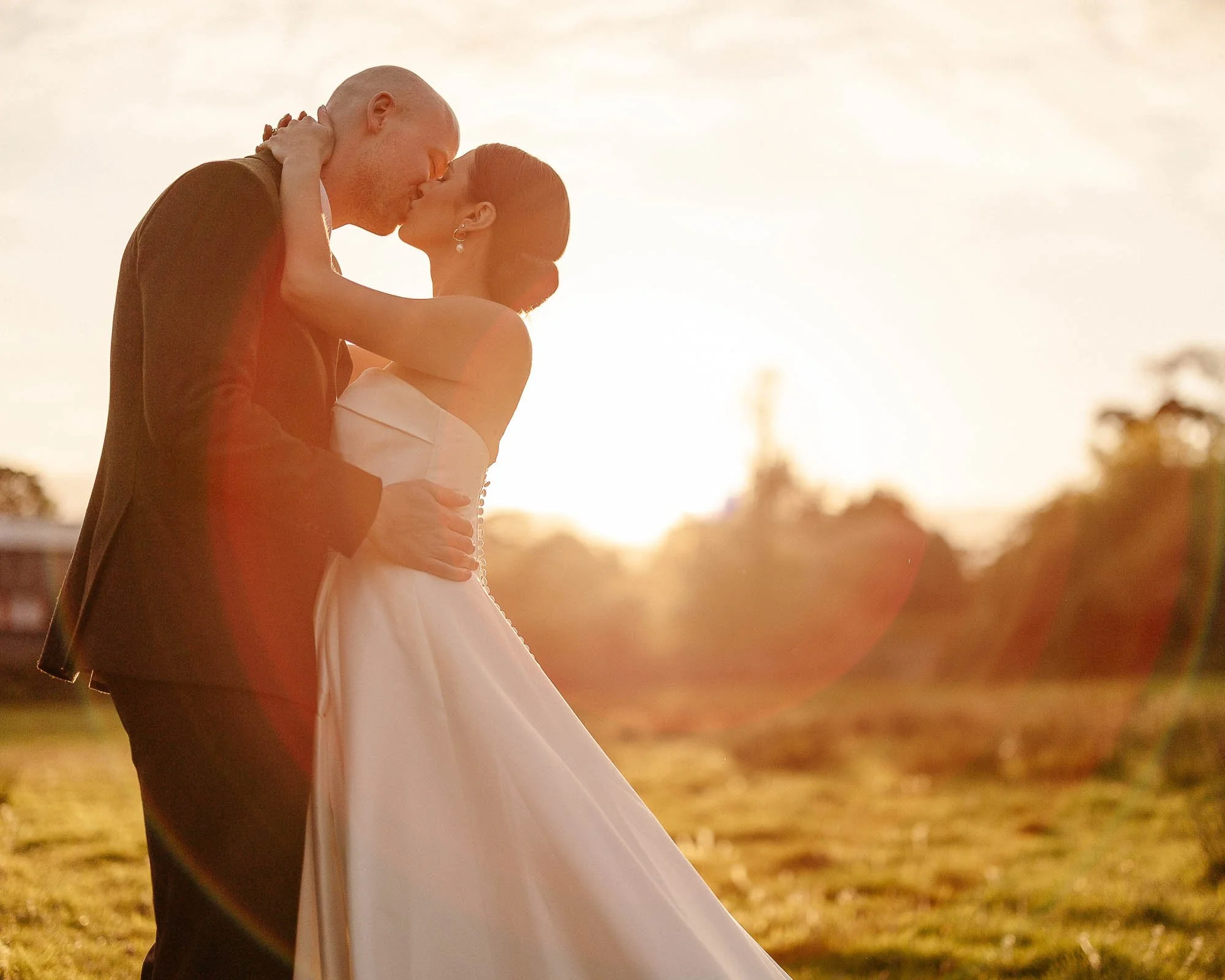 Couple kissing in the sunset on their wedding day at Nancarrow Farm, Cornwall
