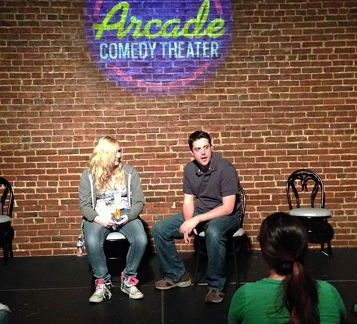 Matt Holmes interviewing Shai, his partner from the audience at a Matt & performance at Arcade Comedy Theater in Pittsburgh.
