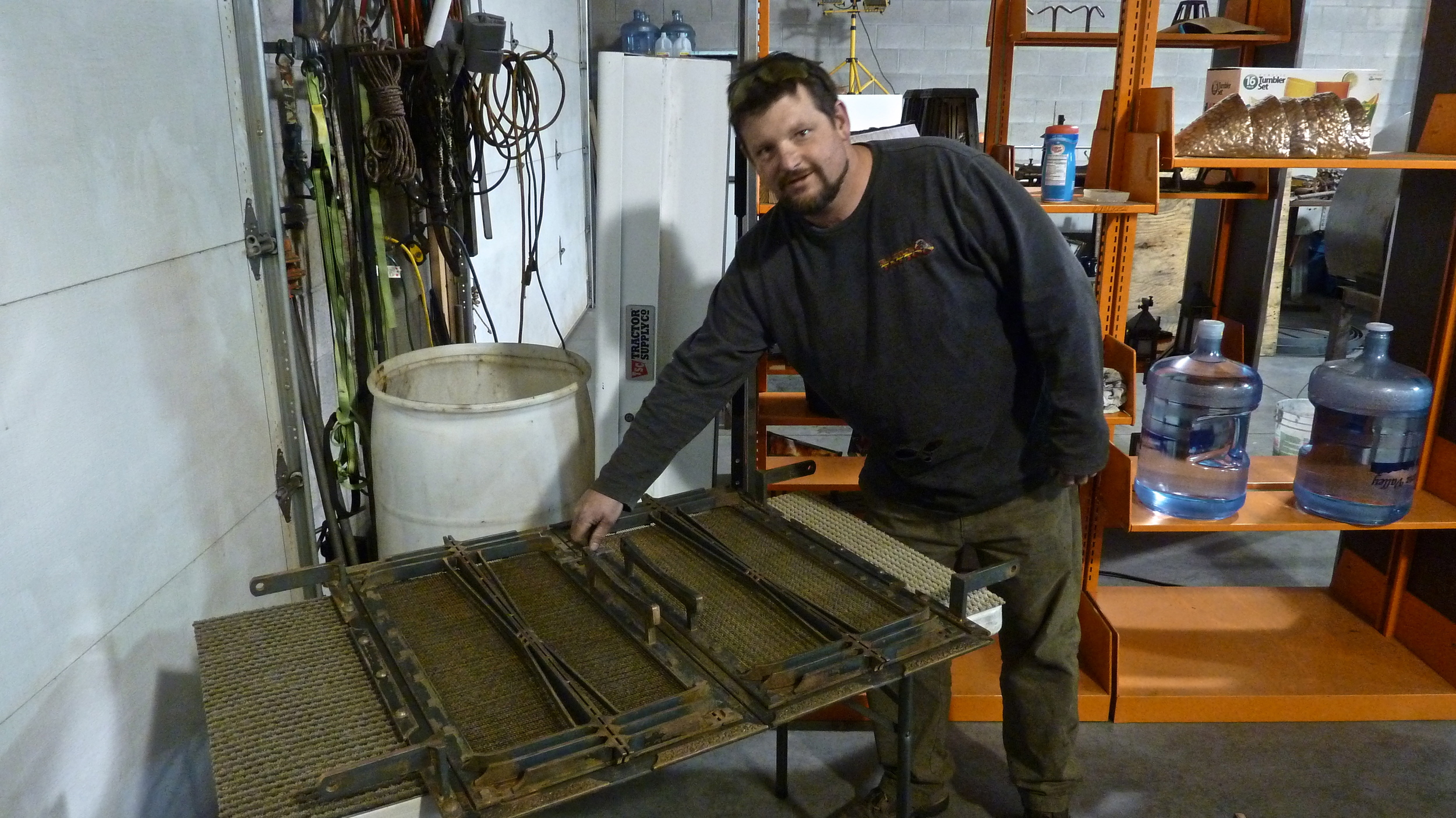 Andy showing a fireplace screen he is manufacturing for a client