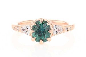 engagement ring with teal oval montana sapphire with pear shaped diamond sides set in rose gold