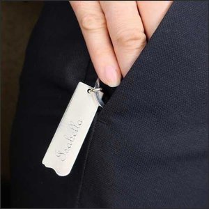hand engraved sterling silver keychain held by model in pocket