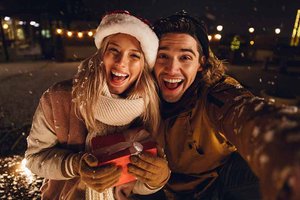 happy young couple with gift in the snow