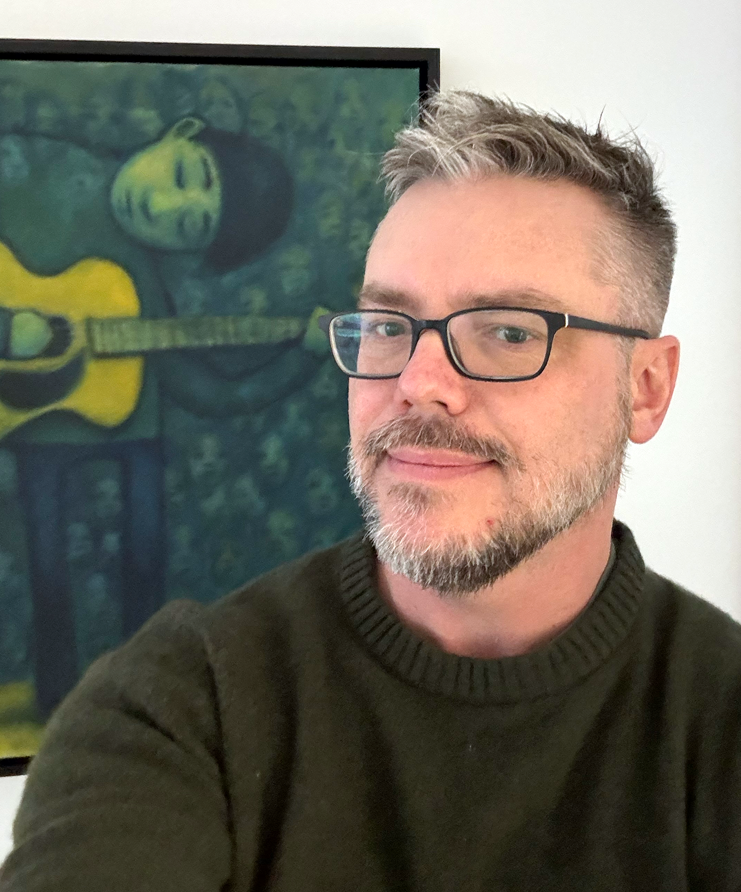 David posing in front of Guitarist Painting