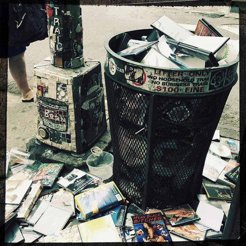 Trash 2 - NYC A trash can filled with pornographic DVDs.