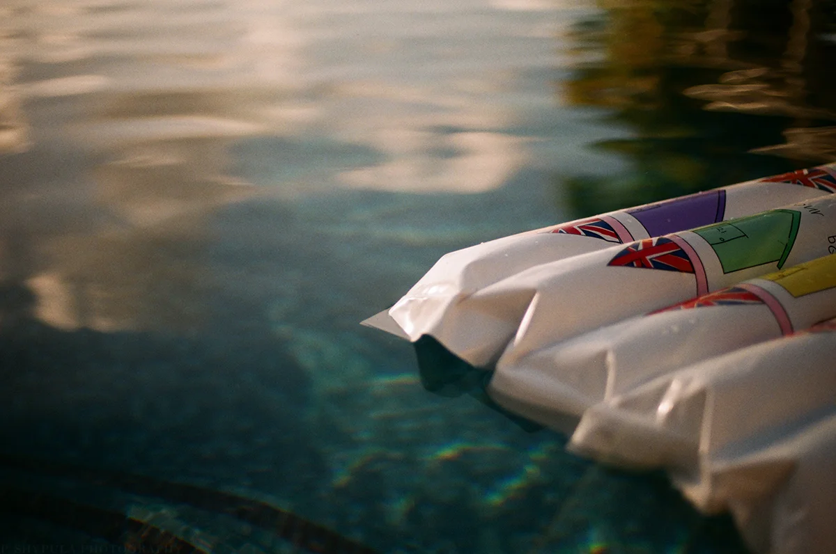 Featuring a pool float with a Daisy de Villeneuve design