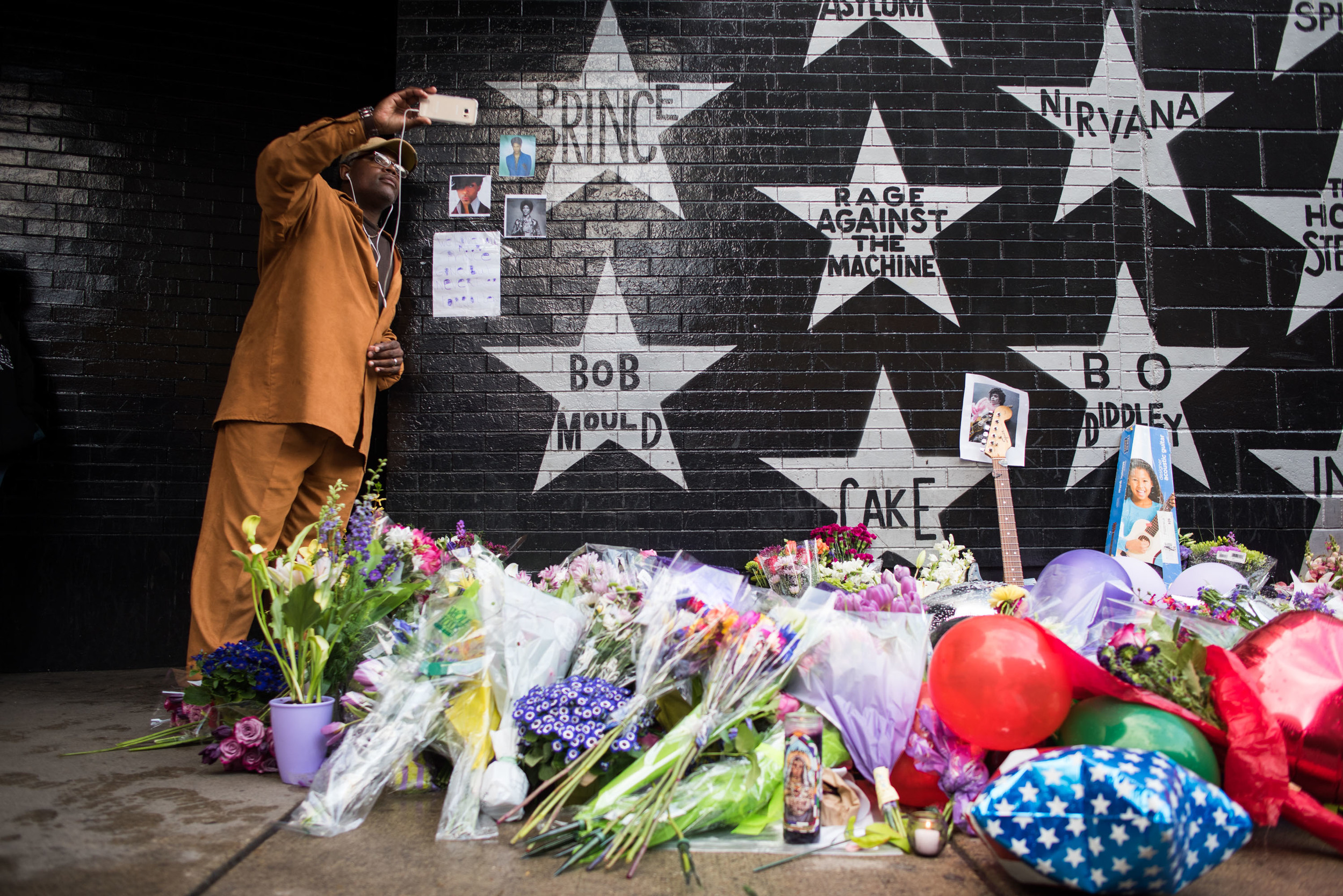 Cederic Riley takes a photo with Prince's star outside of First Ave bellow in downtown Minneapolis. April 21st, 2016.