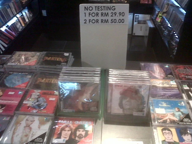 What does a company have to gain by not letting the customer listen to the CD before the purchase. Give me one reason that makes this a cost reducing, revenue increasing, aka profit generating policy.