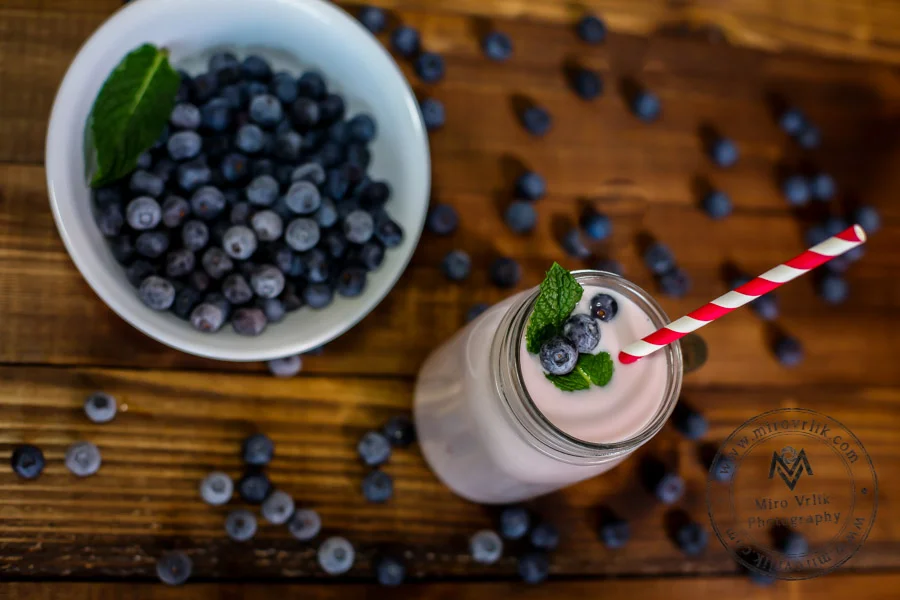 Blueberry smoothies on wooden table top view
