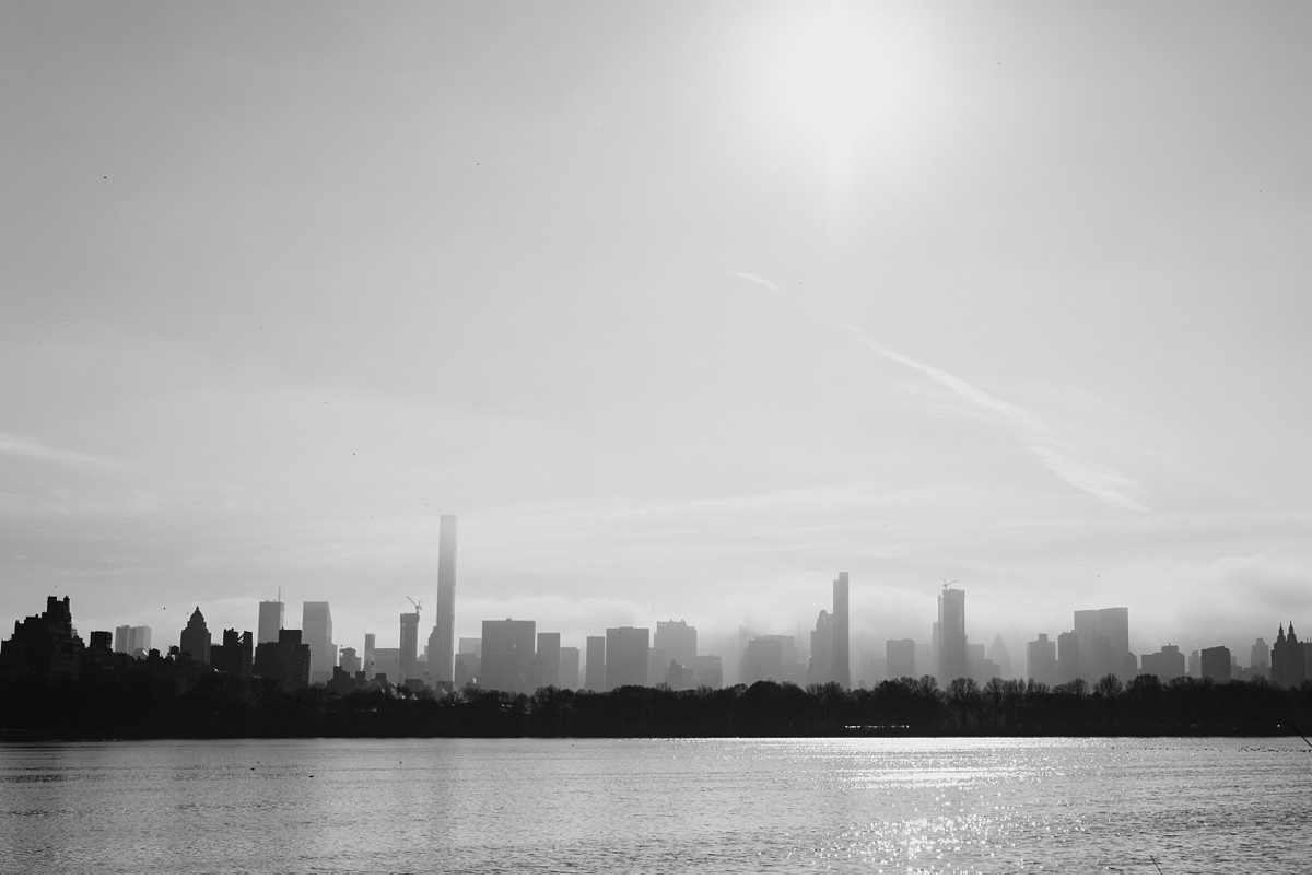 Surreal foggy New York City skyline from Central Park Reservoir.