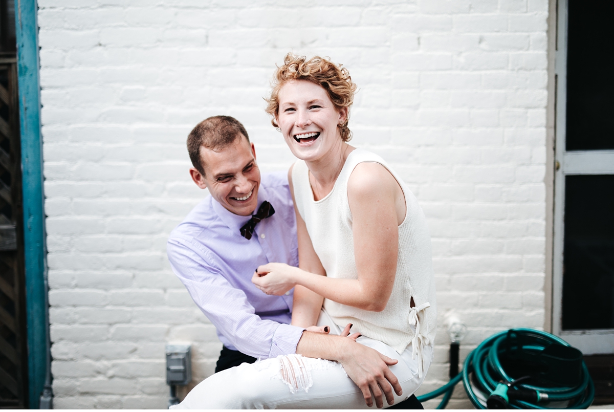 Couple laughing in Boston apartment during engagement session-2