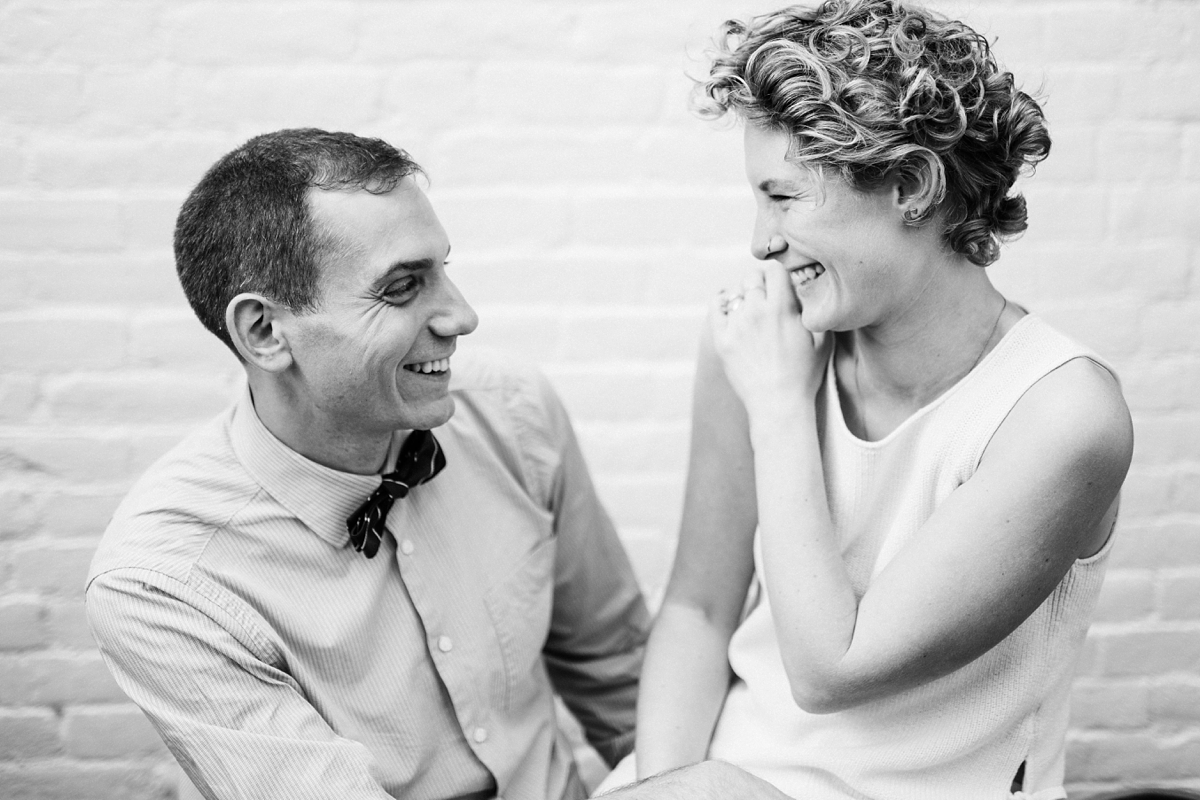 Couple laughing in Boston apartment during engagement session-3