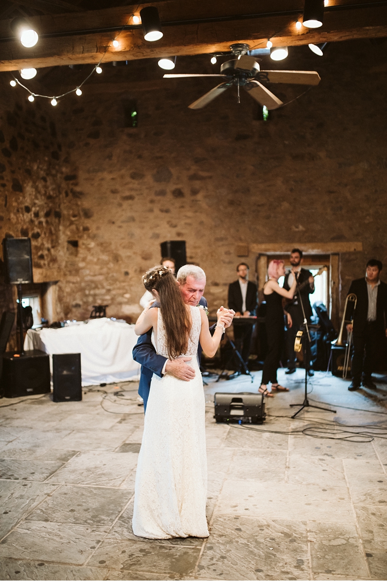 Bride hugging grandfather in stone barn at Willowwood Arboretum