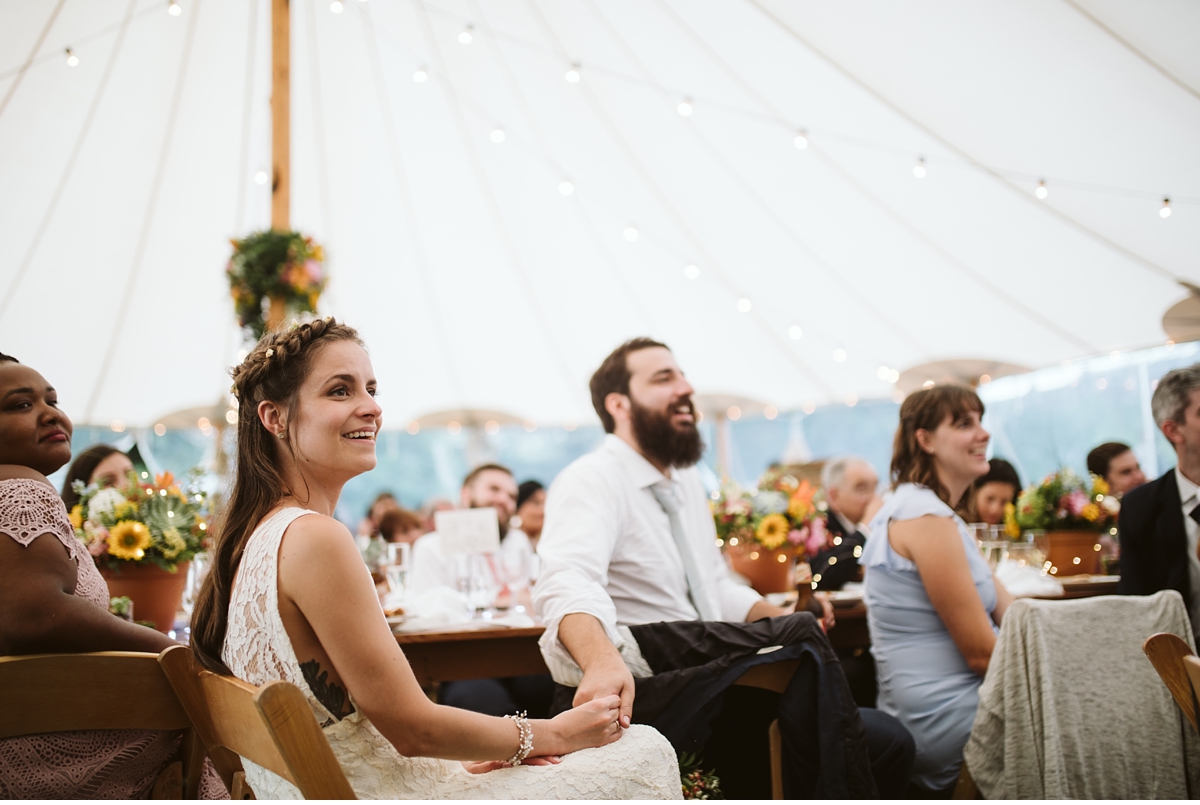 Bride and groom holding hands during dinner at summer wedding