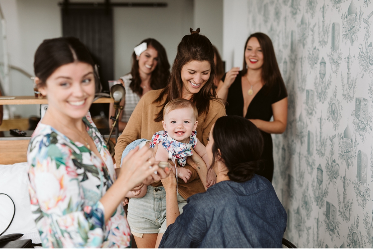 baby smiling at bride in hotel room