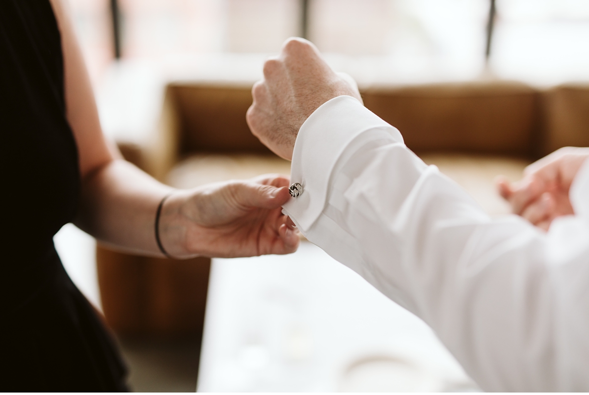 groom putting on cuff links at Wythe hotel