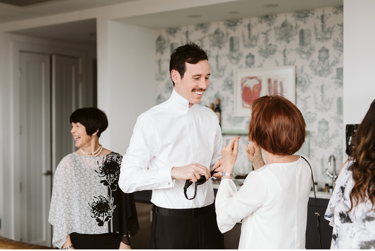 Aunt helping groom with his bow tie